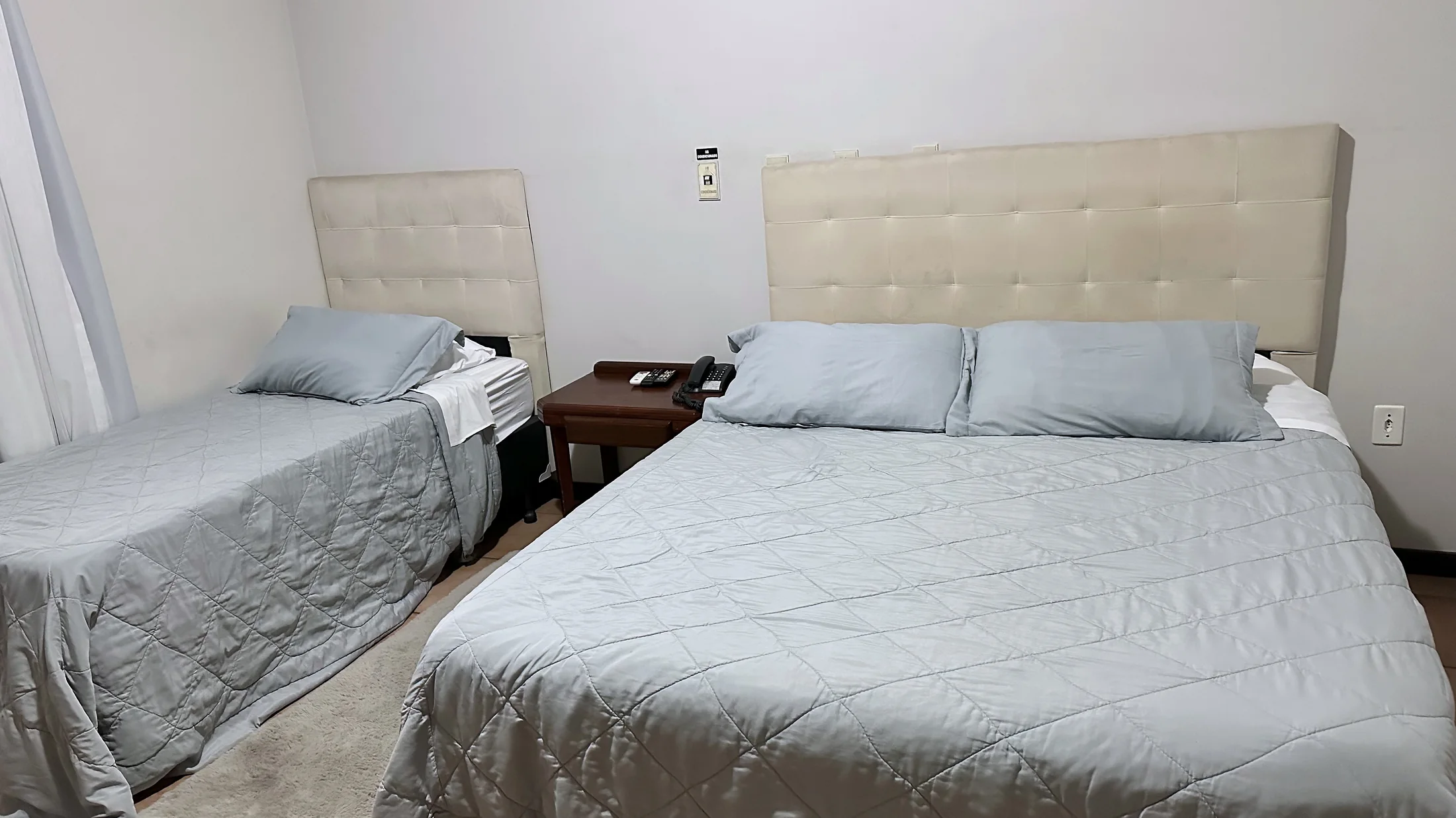 Outro ângulo de quarto do Hotel Beira Rio com cama de casal e cama de solteiro